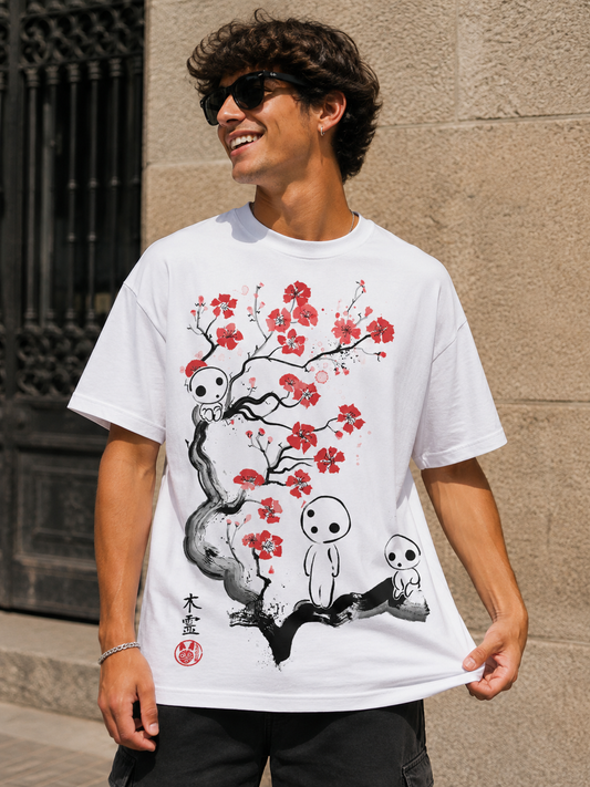 Camiseta blanca con ilustración en tinta japonesa de tres kodama sobre un ciruelo en flor roja, diseño de DRMONEKERS
